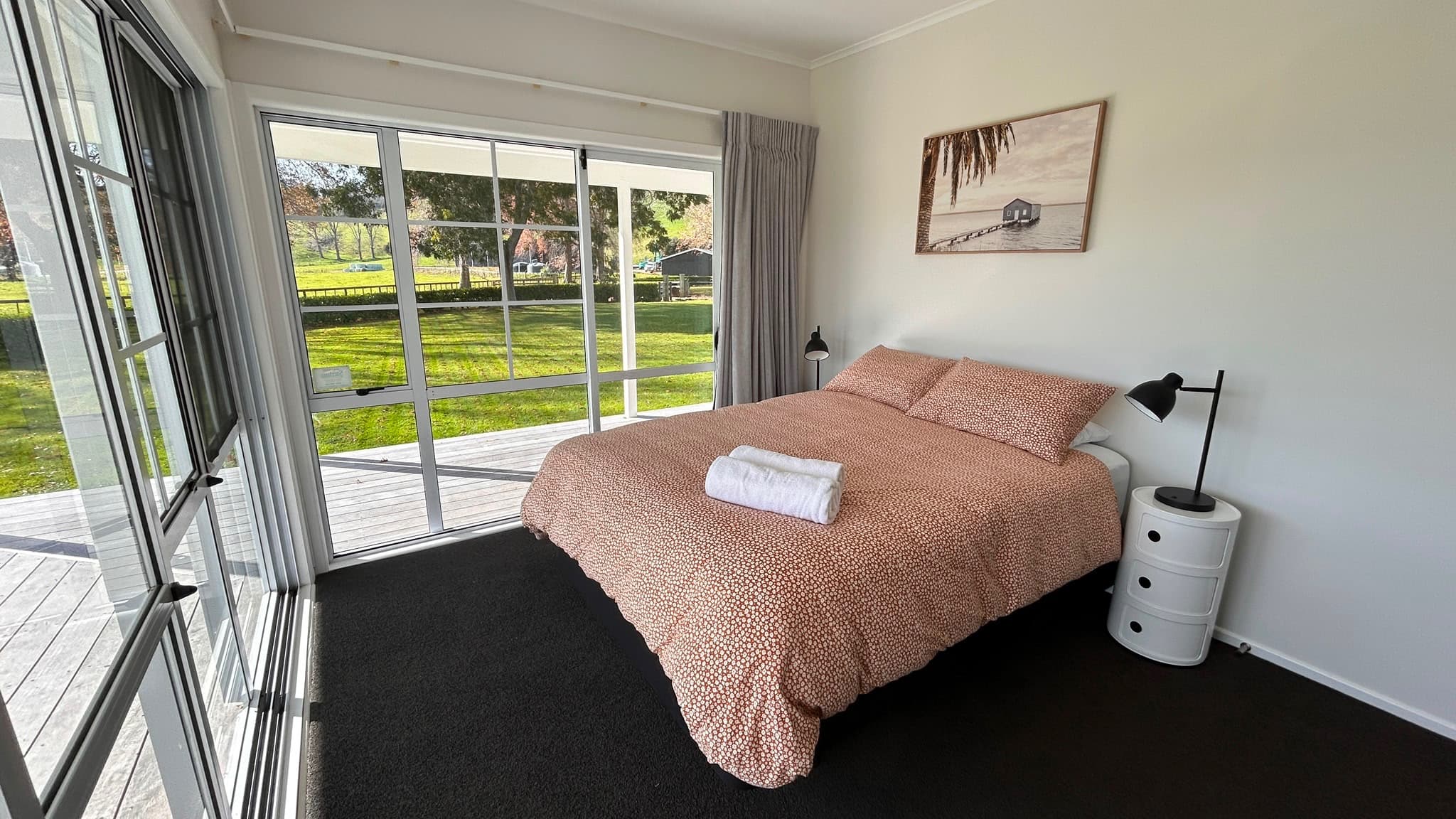 Sunny queen bedroom with direct deck access